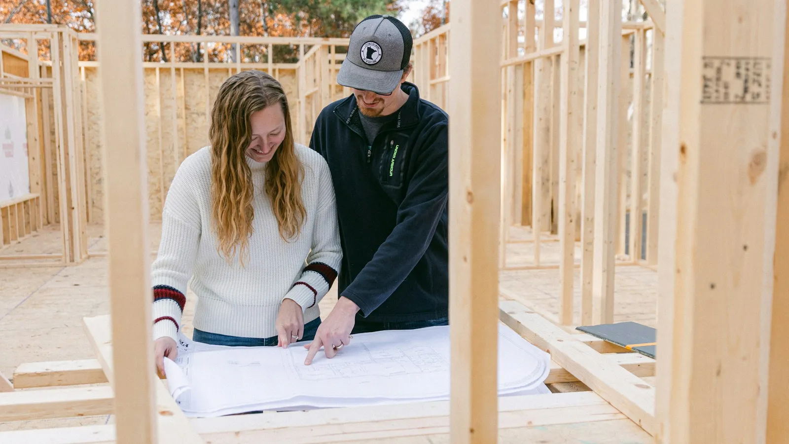 Contractor going over building plans with a homeowner on a job site