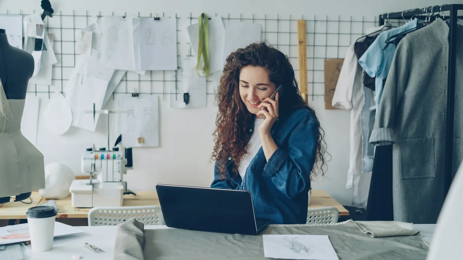 Small business owner on the phone while working on a laptop at her desk