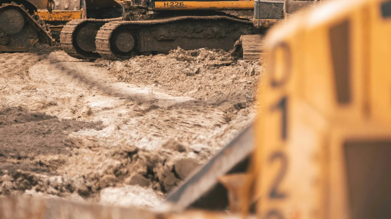 Yellow excavator working on a dirt site