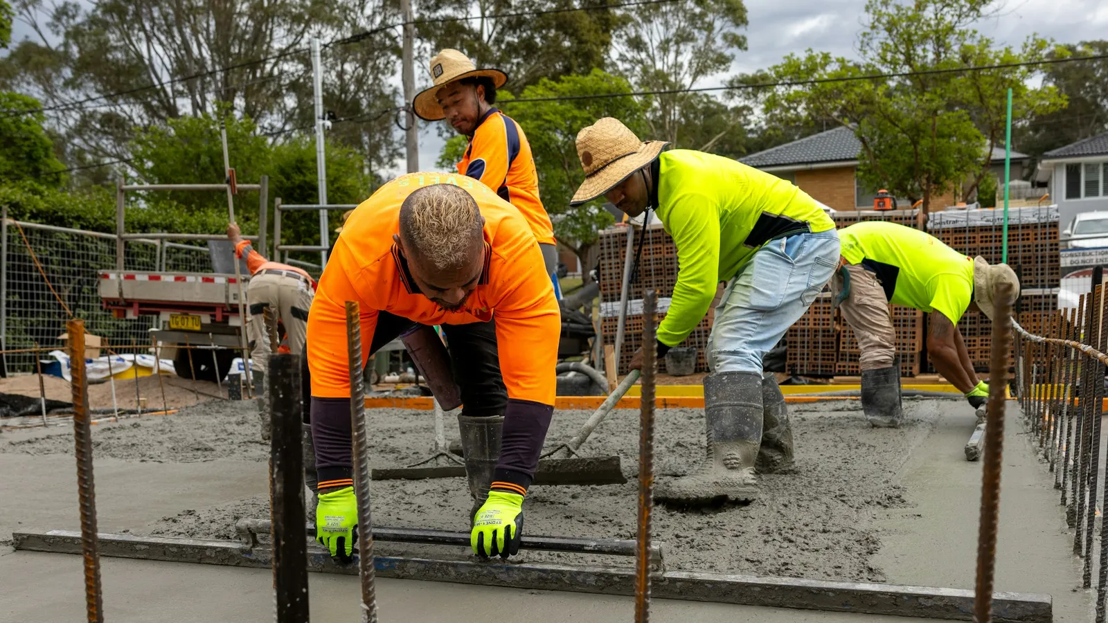 Concrete crew pouring and leveling a slab