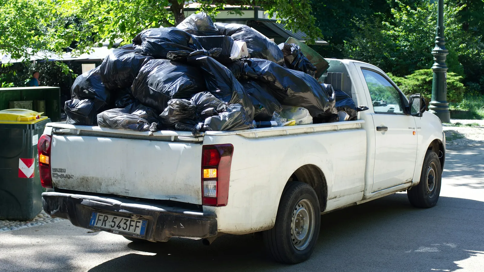 Pickup truck loaded with black trash bags on a residential street