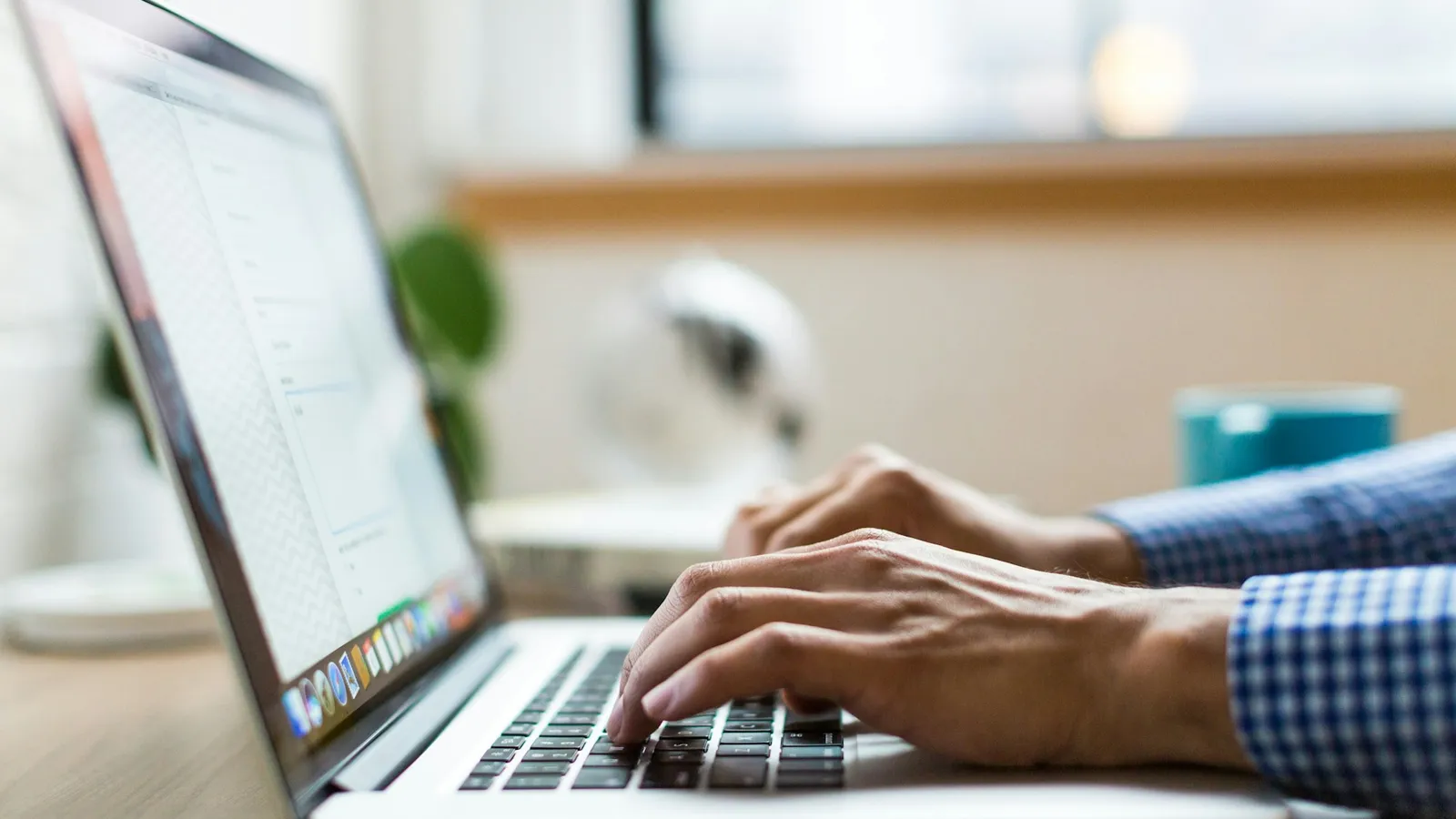 Hands typing on a laptop keyboard