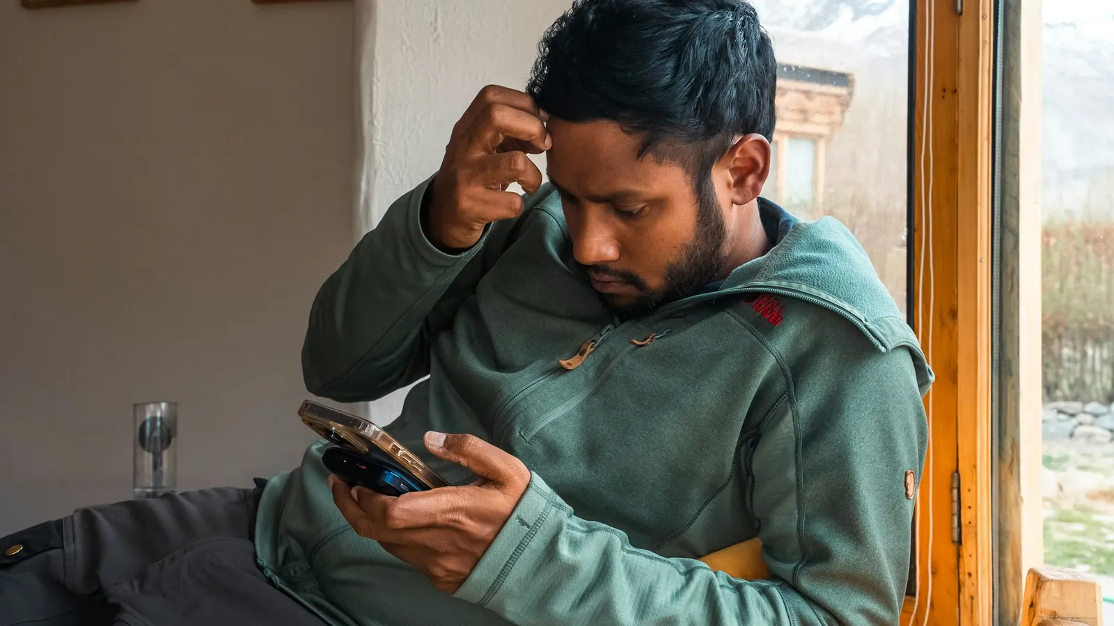 Man looking at his phone, frustrated while a page loads